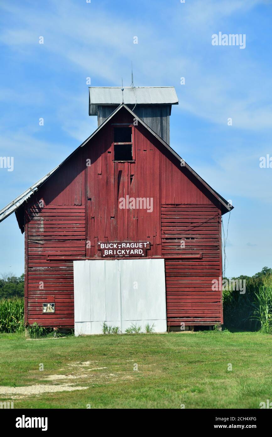 Lacon, Illinois, USA. An old red, wooden barn sits amidst a cornfield along a country road. Stock Photo