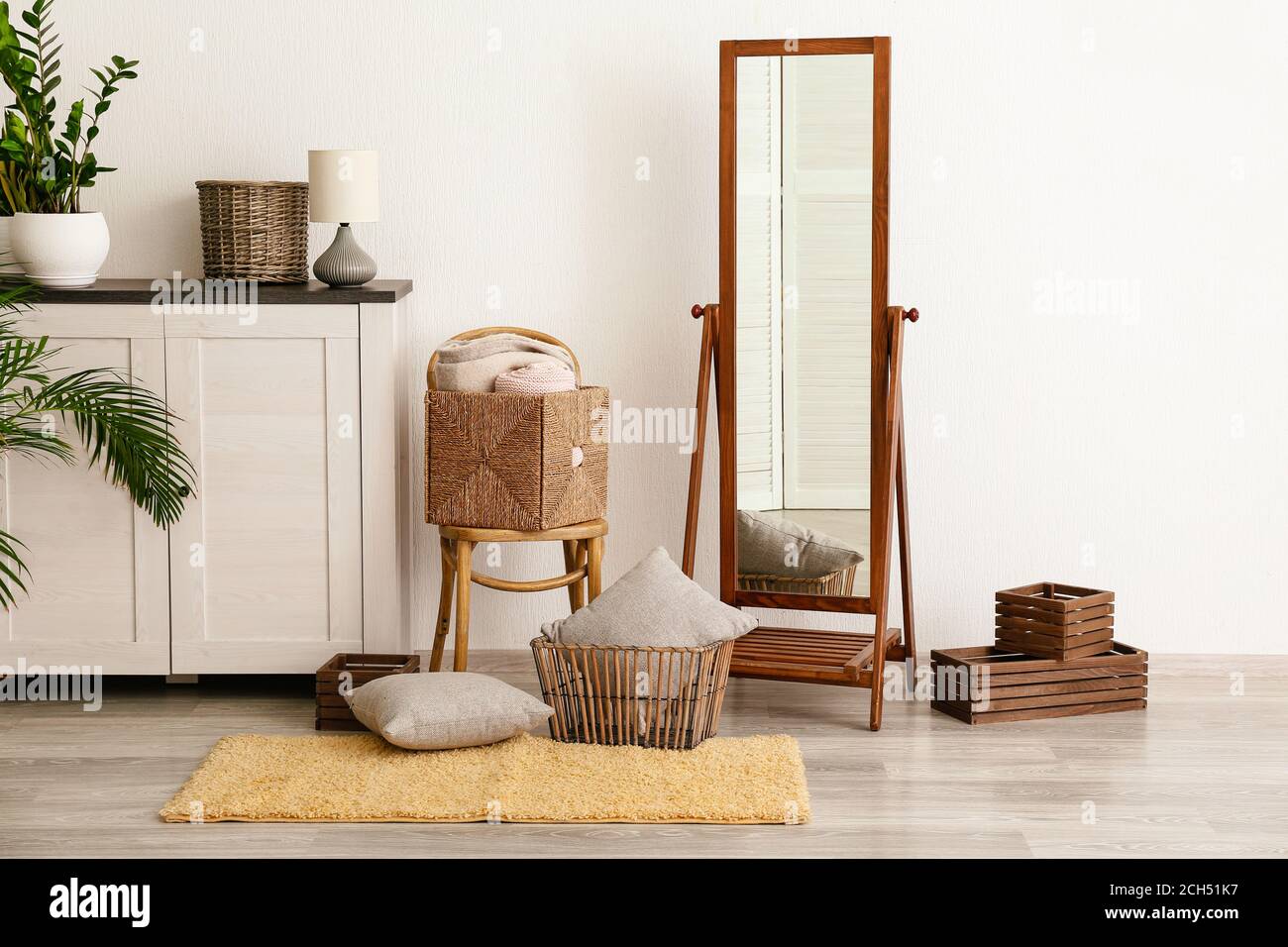 Big mirror, commode with chair, baskets and pillows in room Stock Photo ...