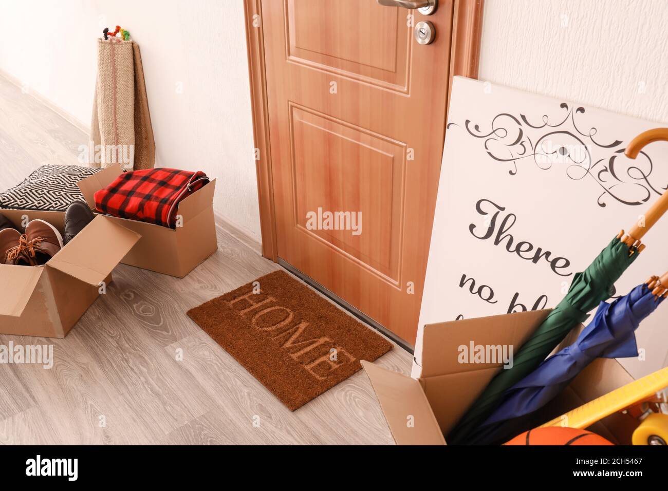 Door mat with moving boxes on floor in hallway Stock Photo Alamy