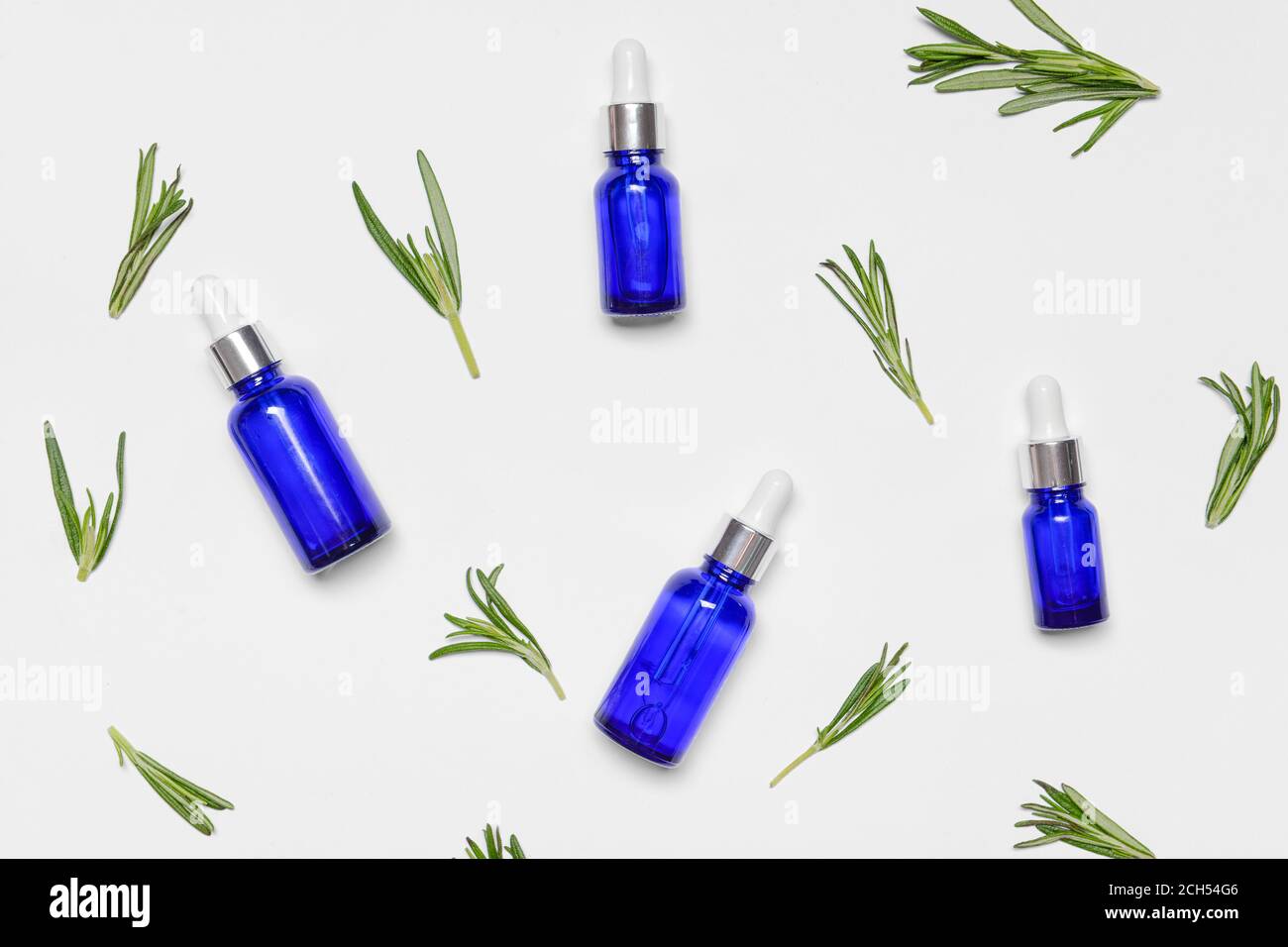 Bottles of rosemary essential oil on white background Stock Photo - Alamy
