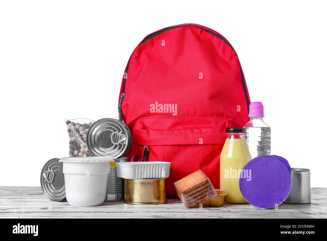 Schoolbag with different products on table against white background ...