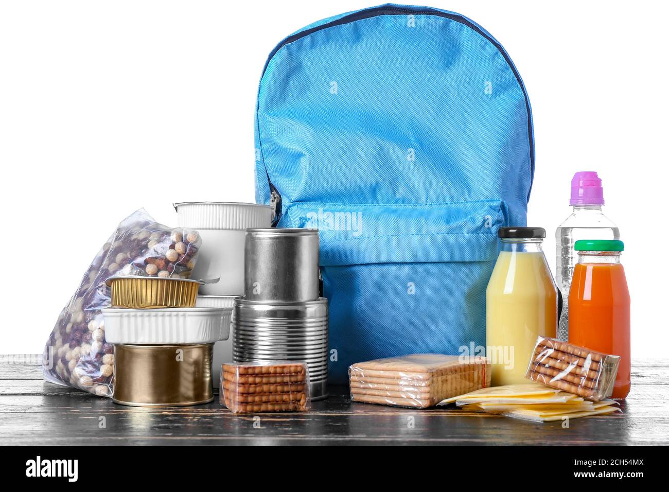 Schoolbag with different products on table against white background ...