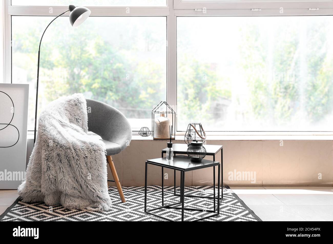 Armchair with table in interior of living room Stock Photo - Alamy