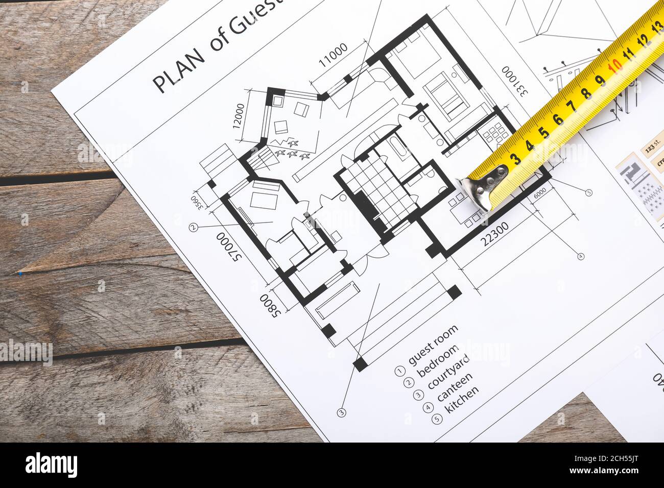 Measuring tape with blueprints on table Stock Photo - Alamy