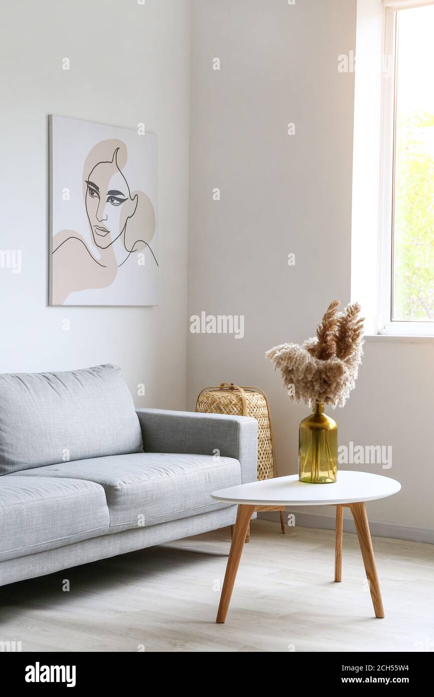 Stylish interior of living room with table and sofa Stock Photo - Alamy