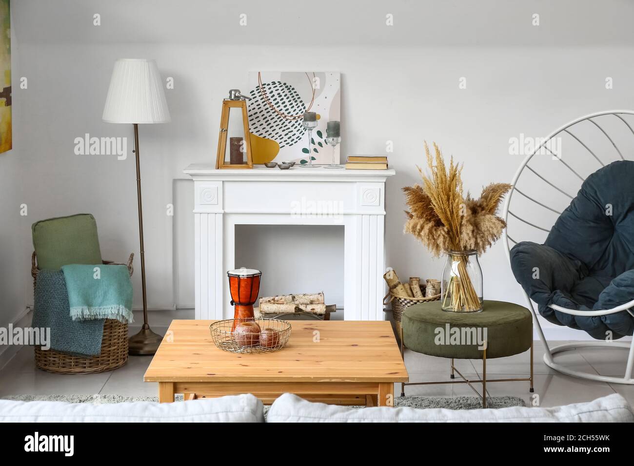 Stylish interior of living room with table and fireplace Stock Photo ...
