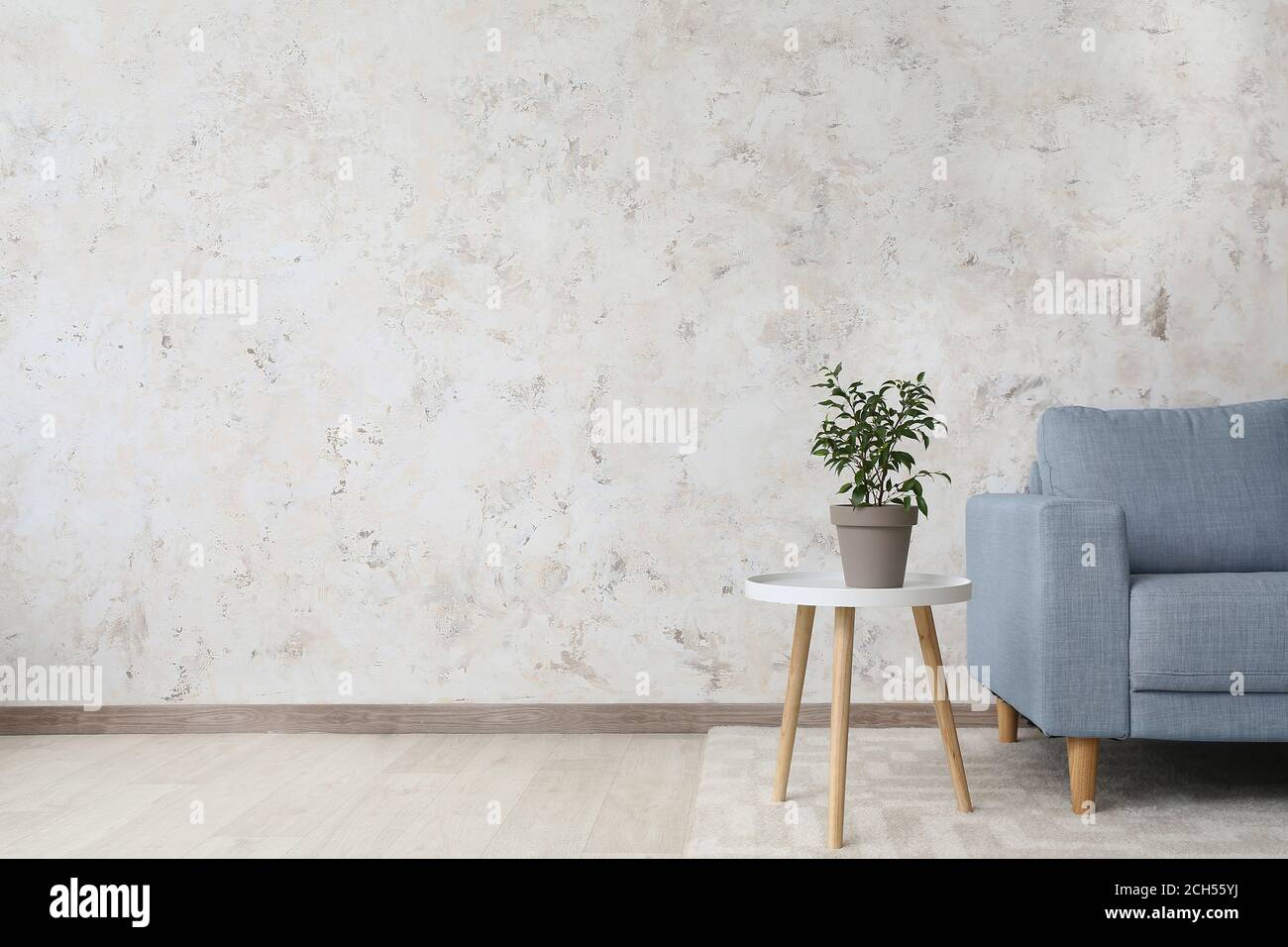 Stylish interior of living room with table and sofa Stock Photo - Alamy