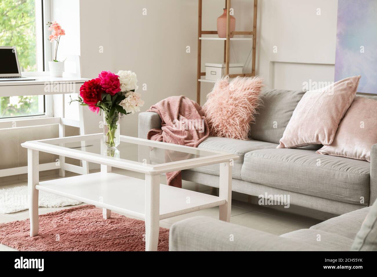 Stylish interior of living room with table and sofa Stock Photo - Alamy