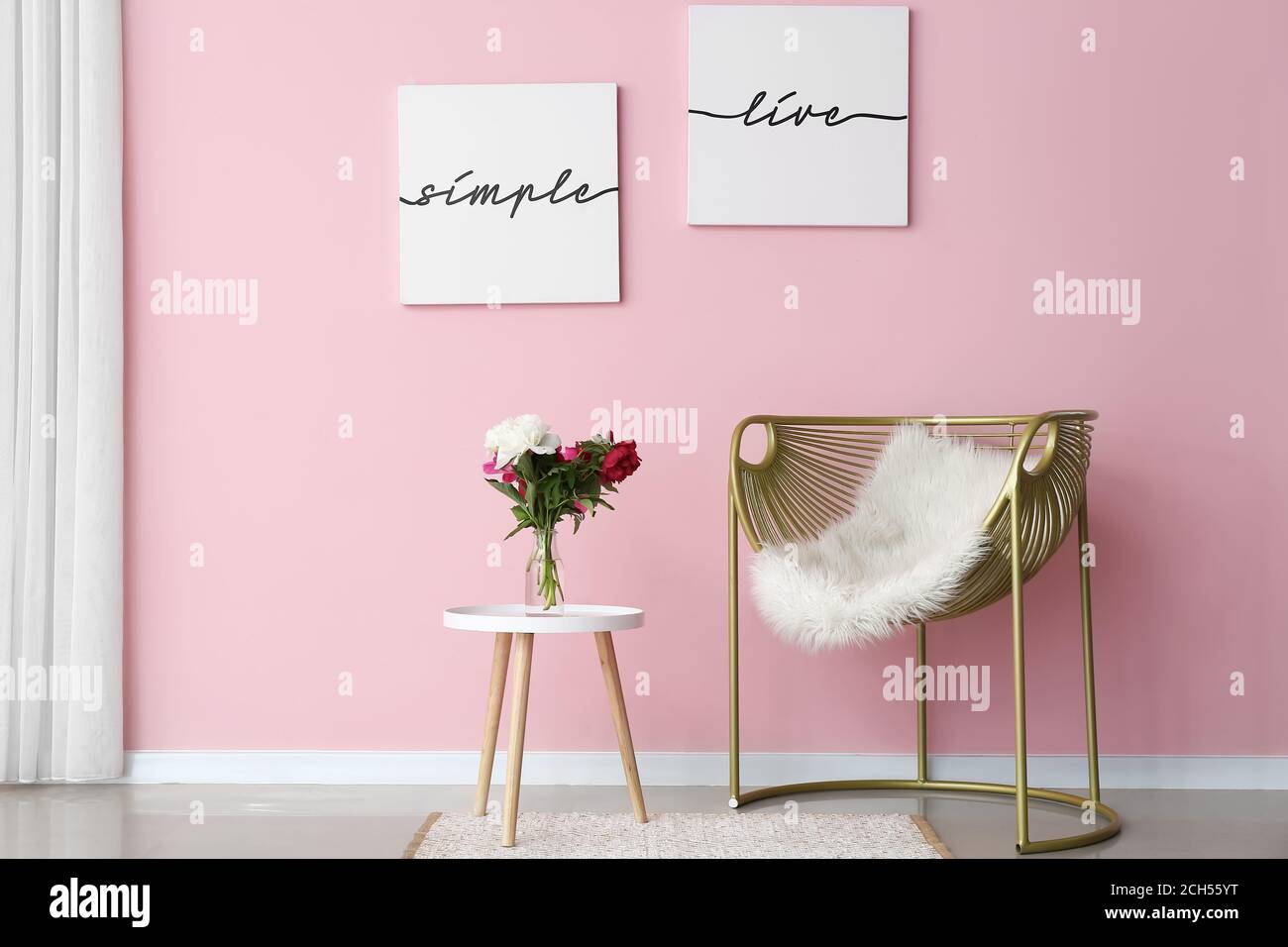 Stylish interior of living room with table and armchair Stock Photo - Alamy