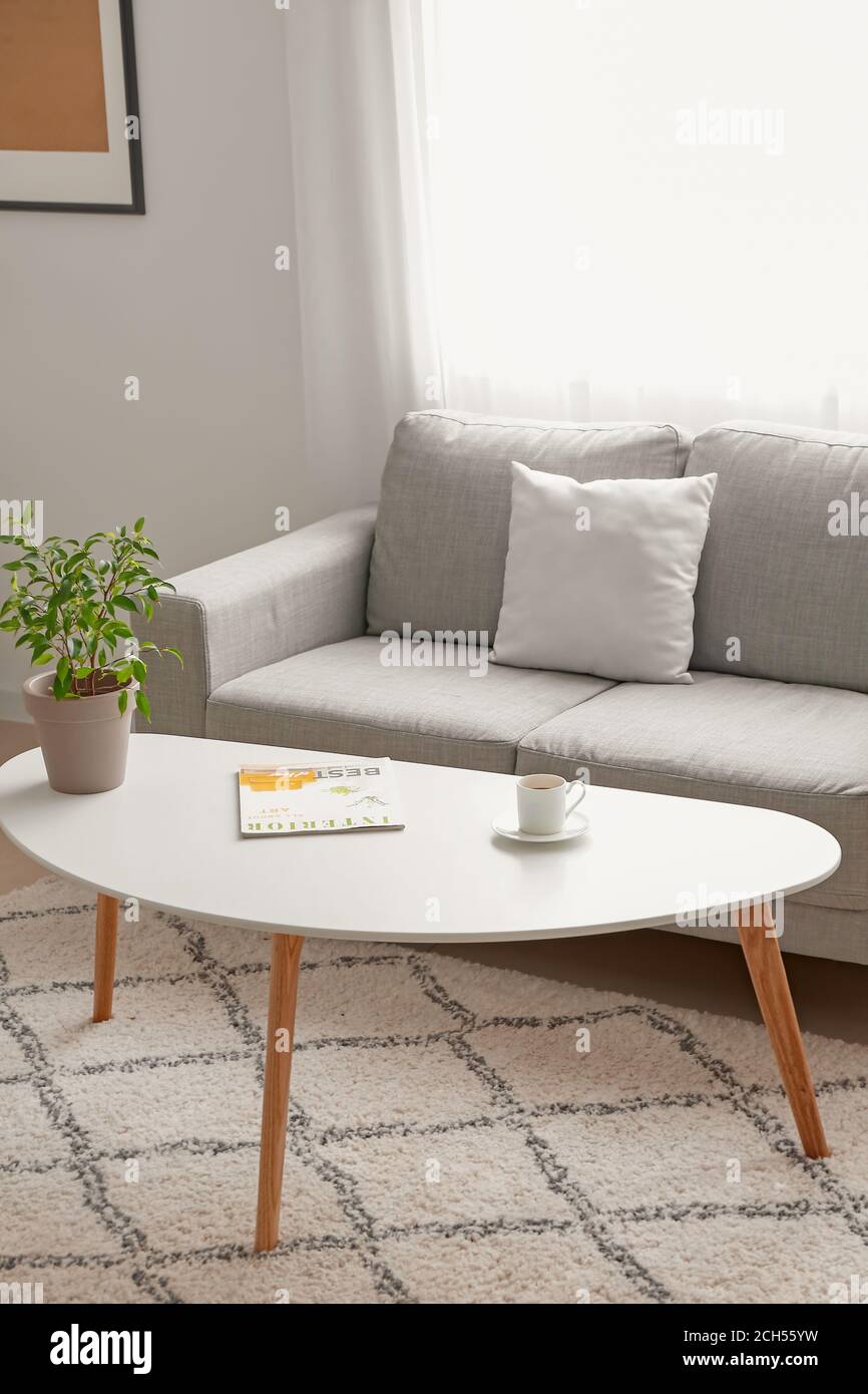 Stylish interior of living room with table and sofa Stock Photo - Alamy