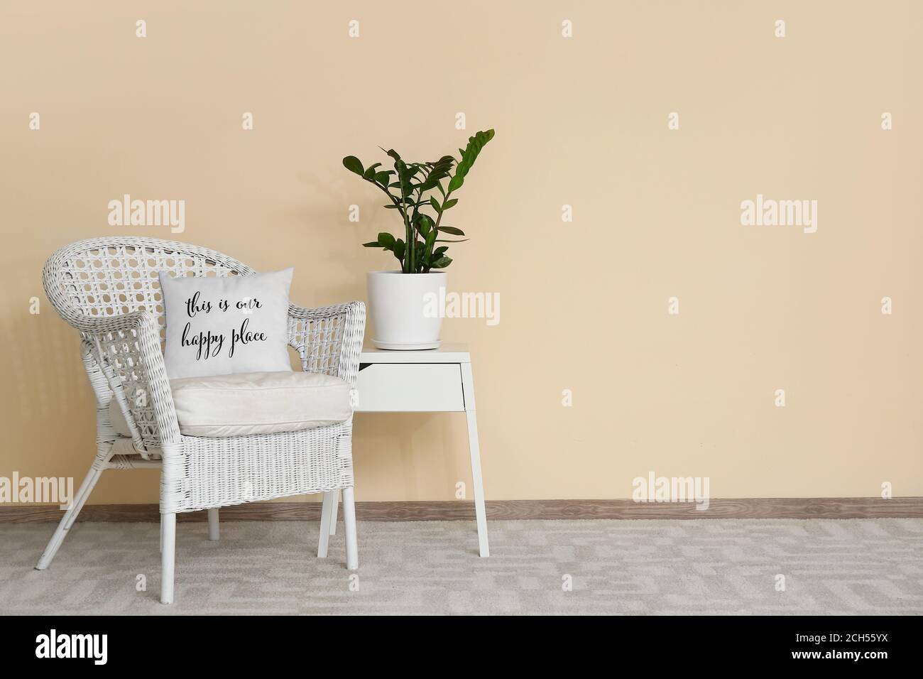 Stylish interior of living room with table and armchair Stock Photo - Alamy