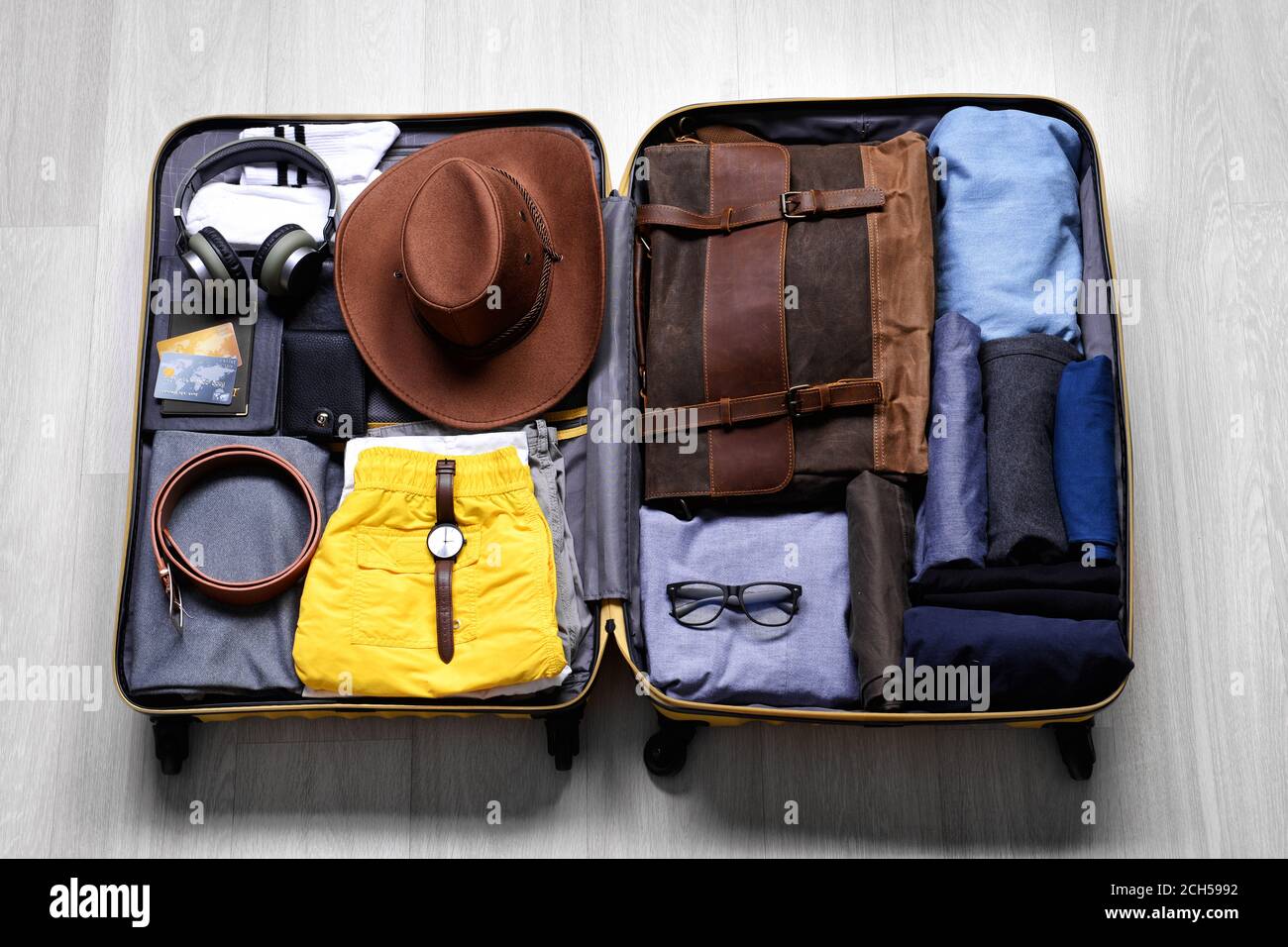 https://c8.alamy.com/comp/2CH5992/open-packed-suitcase-on-wooden-background-travel-concept-2CH5992.jpg