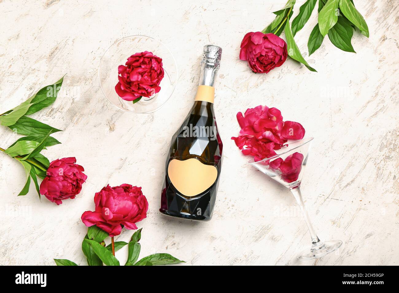 Bottle of champagne and flowers on light background Stock Photo - Alamy