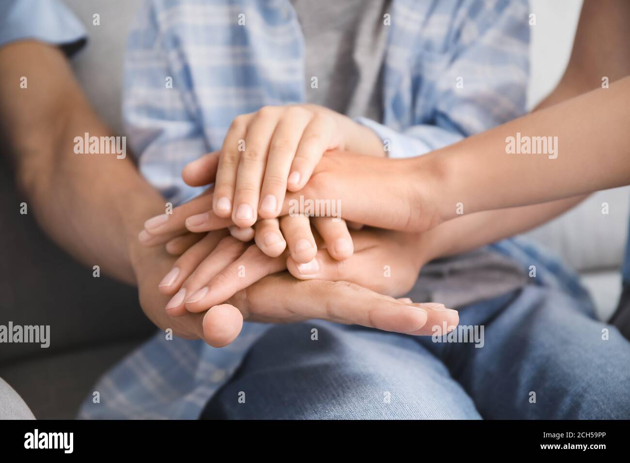 Family holding hands together at home, closeup Stock Photo - Alamy