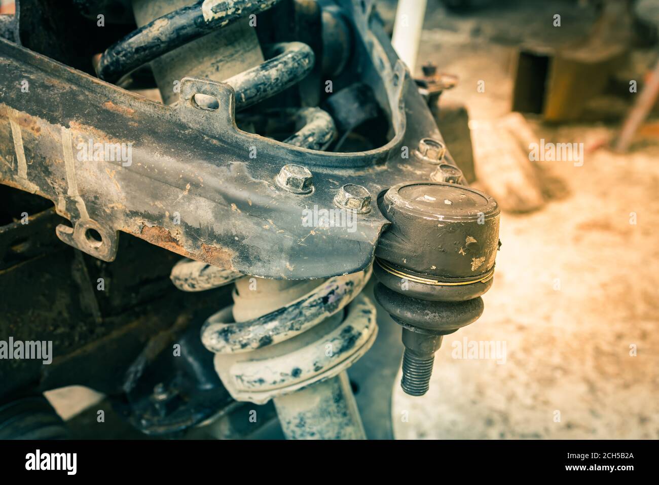 Zoom View Auto Part Upper Arm Ball Joint and Coil Spring and Shock Absorber and Chassis of Car in Vintage Tone Stock Photo