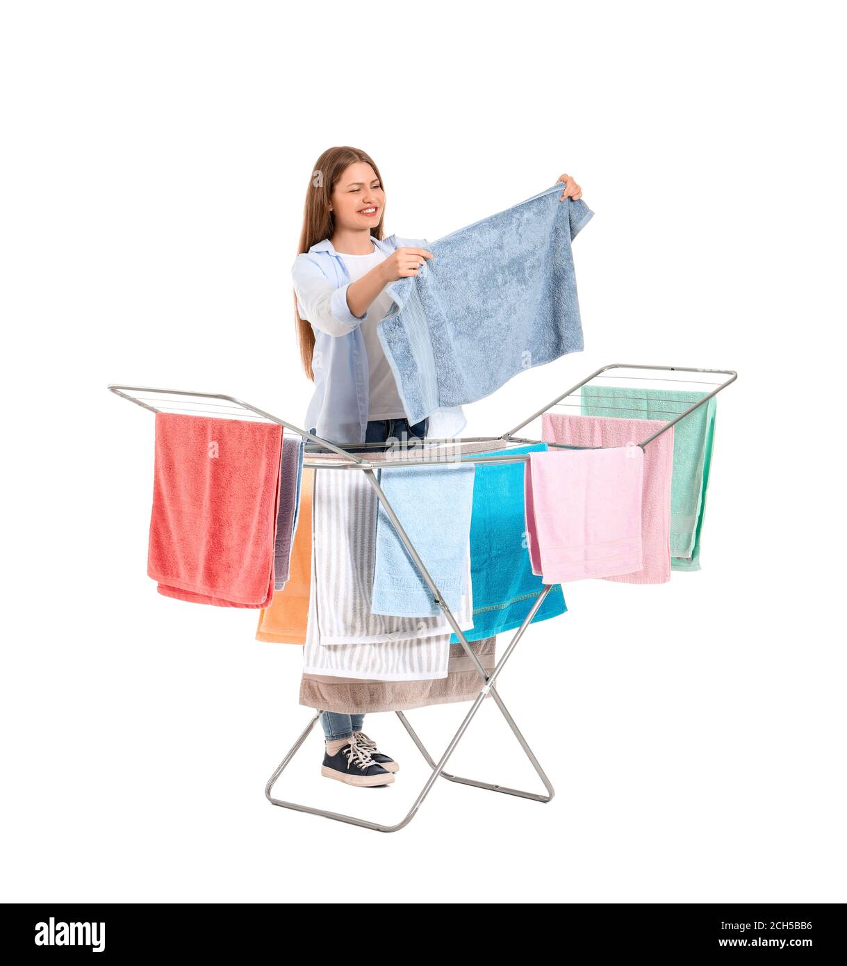 Woman with clean towels and clothes dryer on white background Stock