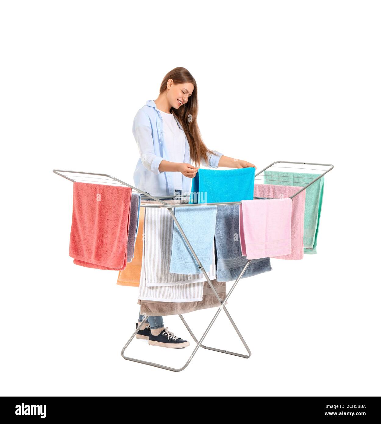 Woman with clean towels and clothes dryer on white background Stock