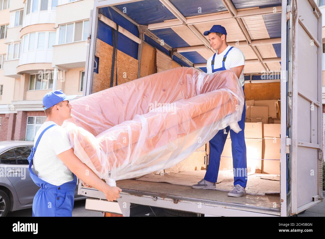 Loaders taking furniture from truck Stock Photo Alamy