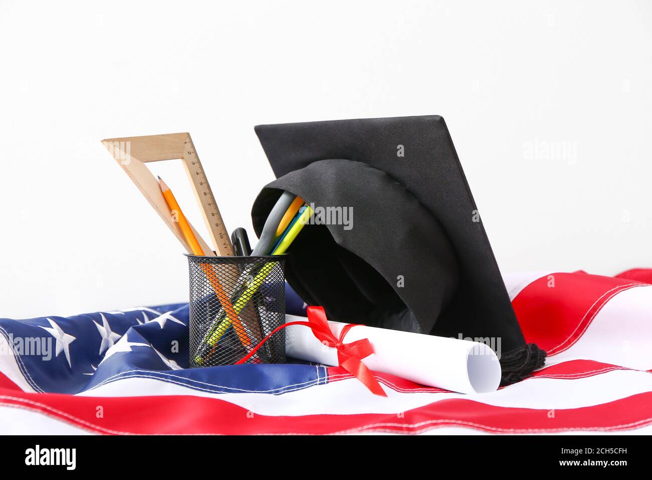 Graduation hat, stationery, USA flag and diploma on white background ...