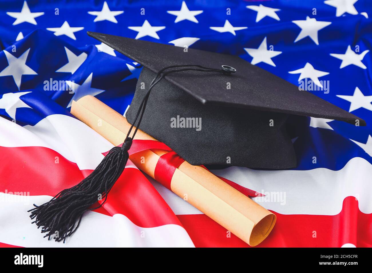Graduation hat and diploma on USA flag Stock Photo - Alamy