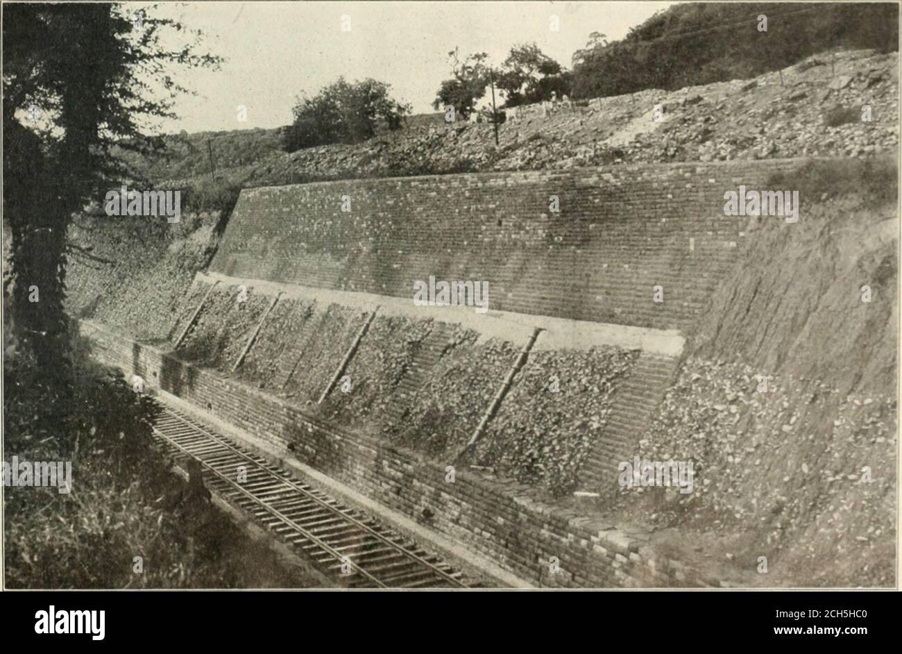 . Railway age . Retaining Walls and Road Bed.. Revetment Wall and Drains in Durrah Hill Cut; Nagda-Muttra State Railway. 678 tHE RAILROAD GAZETTE. Vol XLIV, No. l6. below the ballast. Where the soil Is most treacherous, a confreteilraln has hci/i l)iillt h:ilf-w.iy up tlie slope to Interrupt the rain-fall. Above (111- (liain the soil Ik revetted with dry stone up to tha topor the slope. Uelow the drain are dry stone counterforts and earth-enware pipes carrying the rainfall Into the solid masonry drainsat foundation level. We are Indebted to Indian hUiginvi-iimj for I he photoRiaphsand the deta Stock Photo