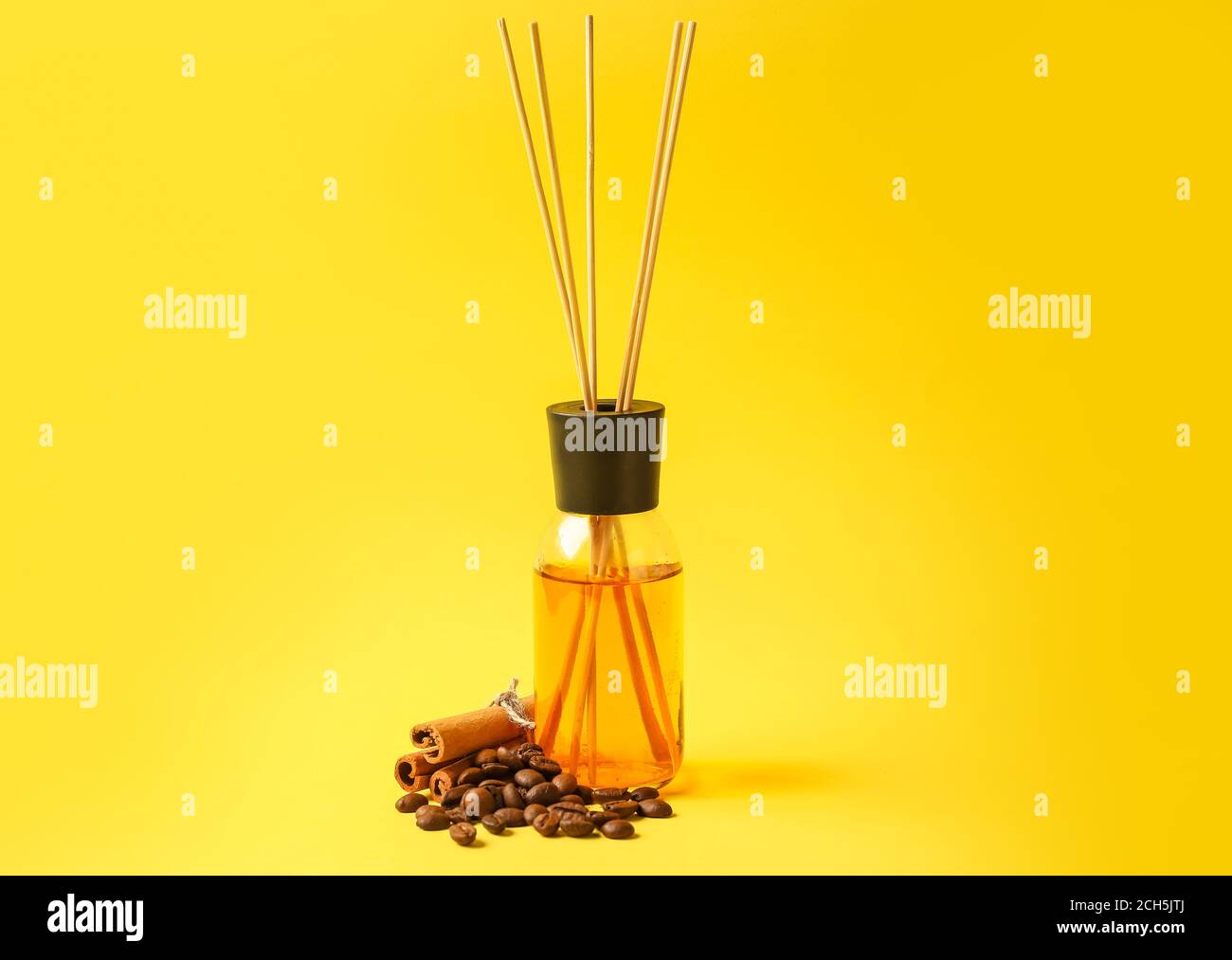 Reed diffuser with coffee beans and cinnamon on color background Stock Photo