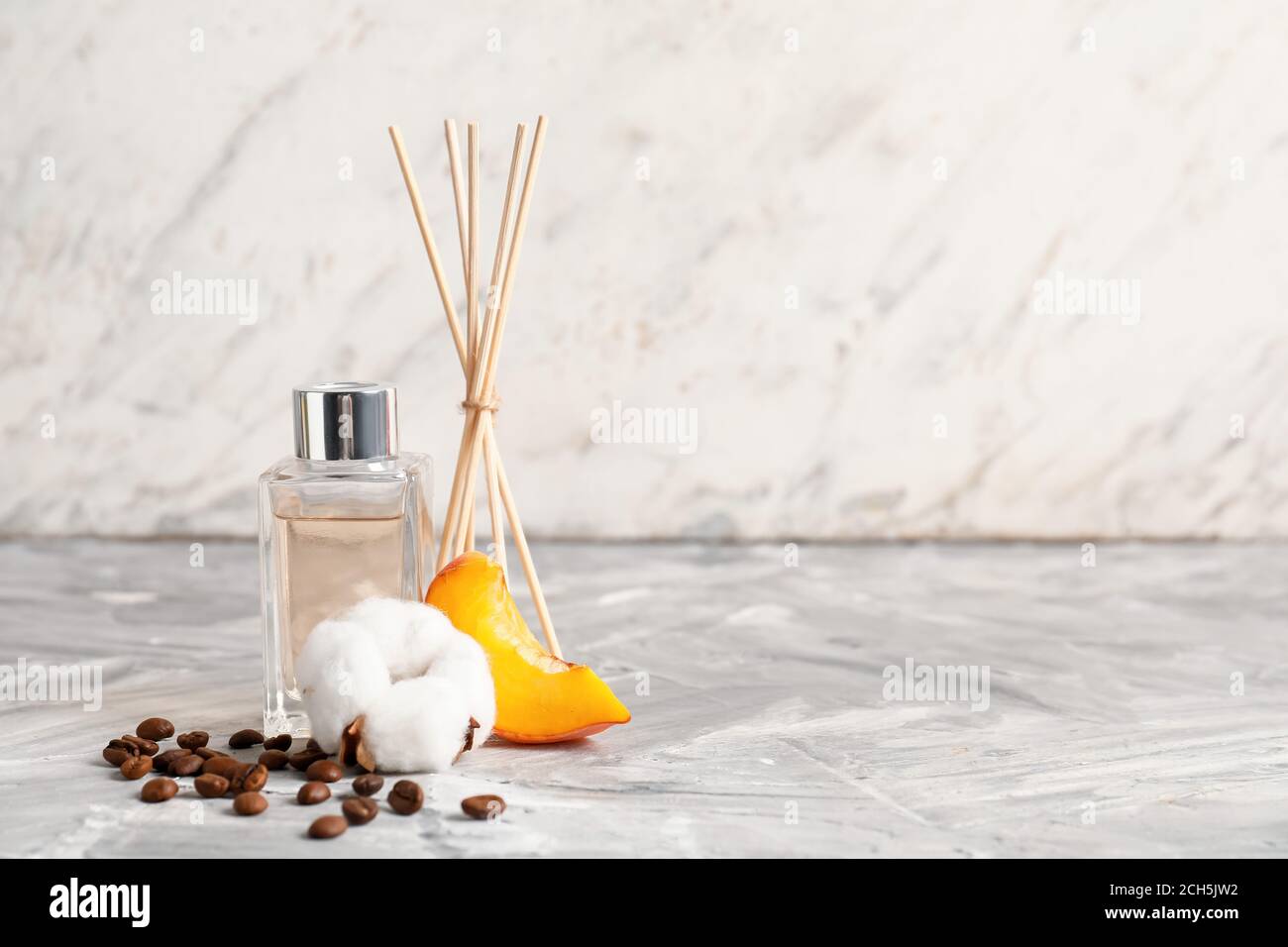 Reed diffuser on table against light background Stock Photo