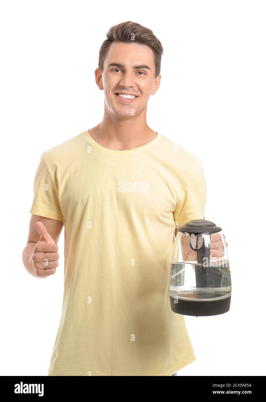 Young man with electric kettle showing thumb-up on white background ...