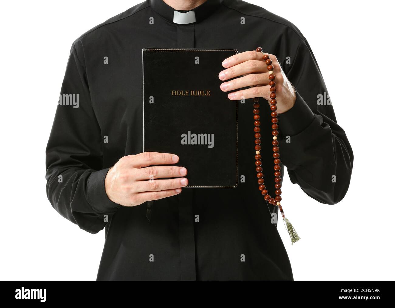 Handsome priest with Bible and rosary beads on white background Stock Photo