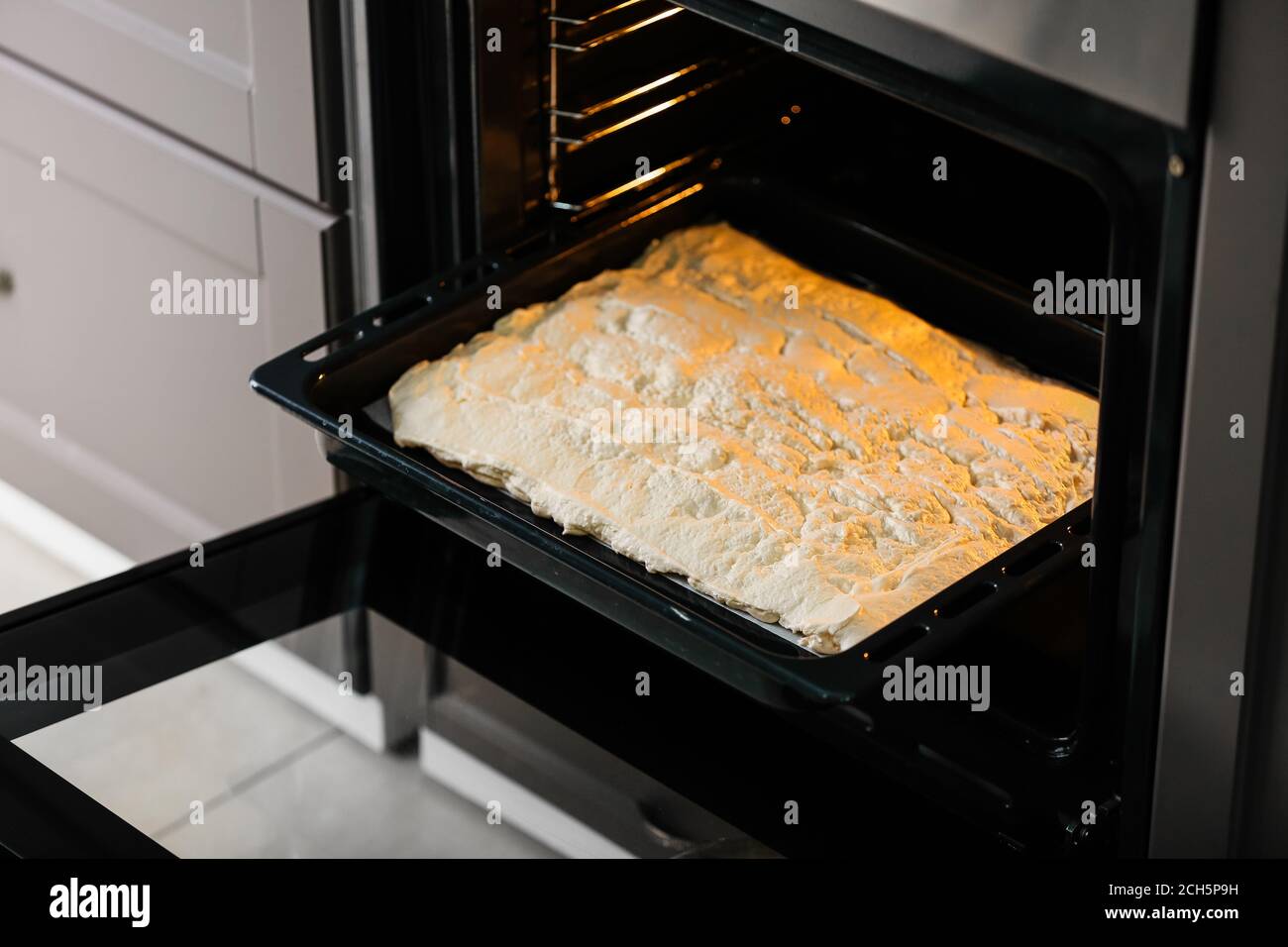 Baking sheet with meringue in oven Stock Photo Alamy