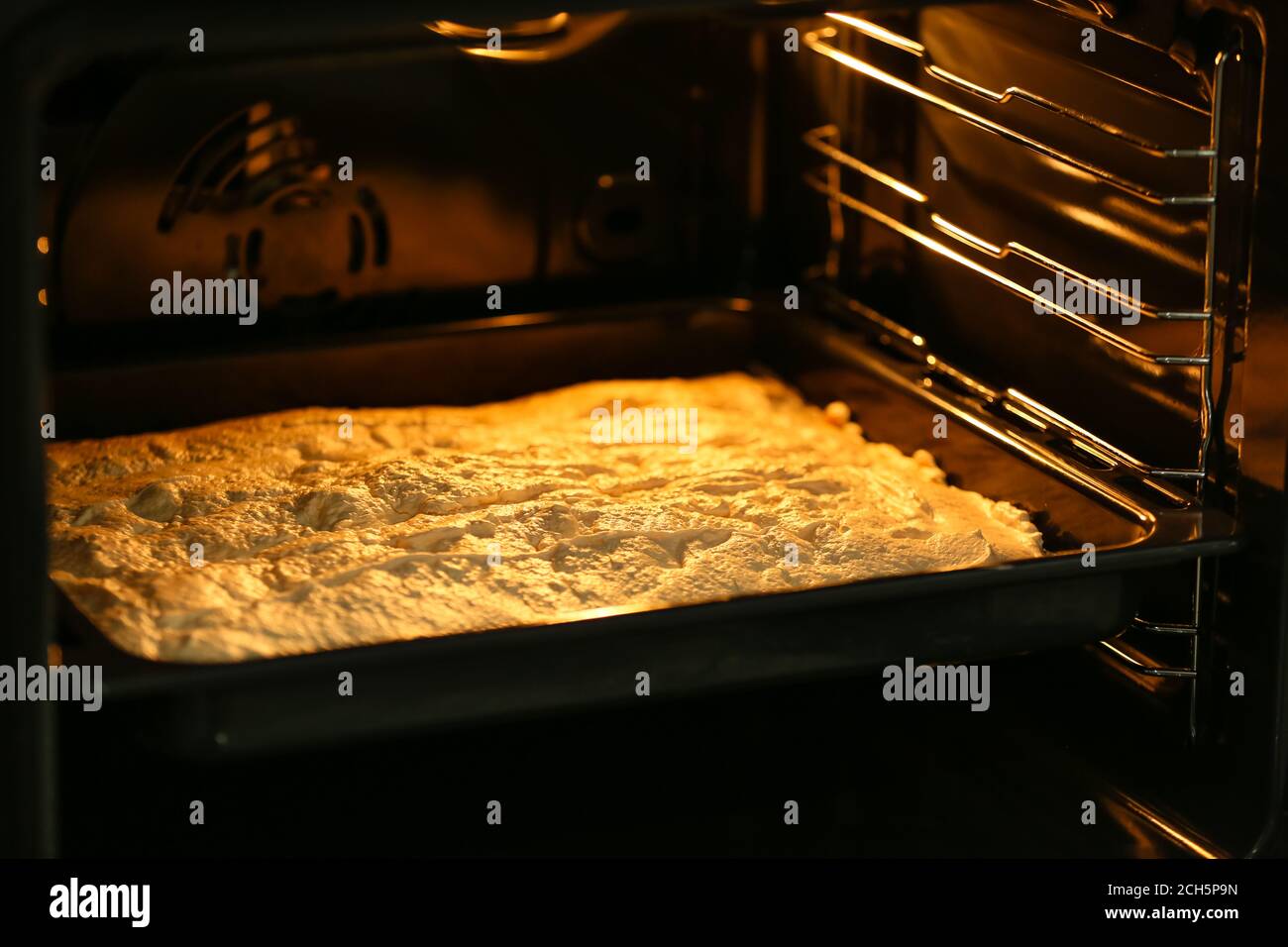 Baking sheet with meringue in oven Stock Photo Alamy