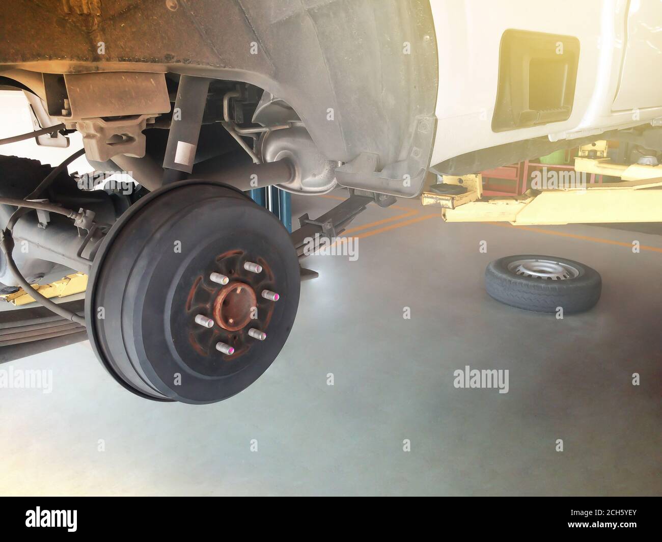 Wheel hub and truck tire in process of changing and maintenance pickup truck wheel alignment in service in a garage. Focus on wheel hub. Stock Photo