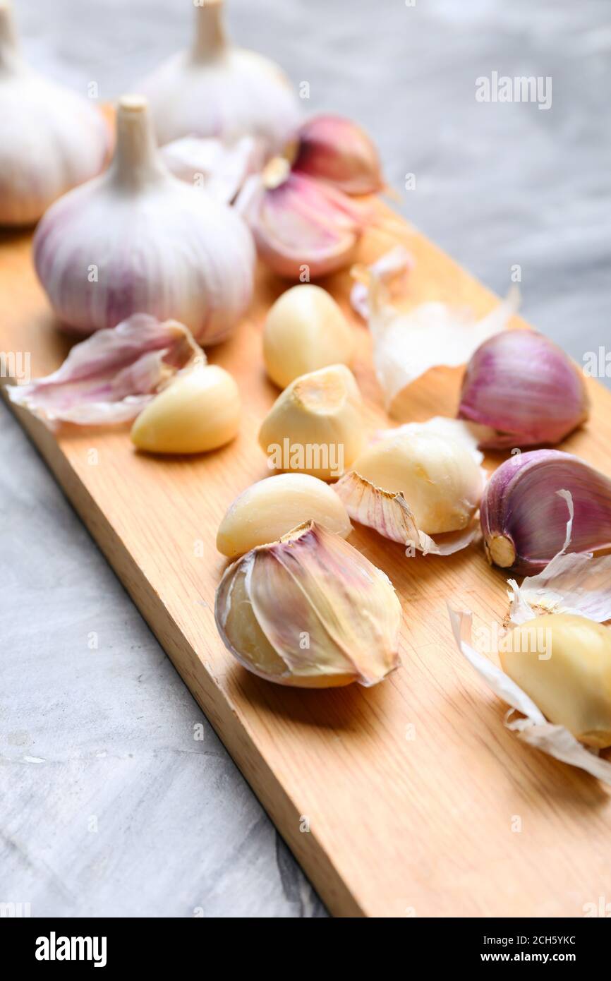 Board with fresh garlic on grey background Stock Photo - Alamy