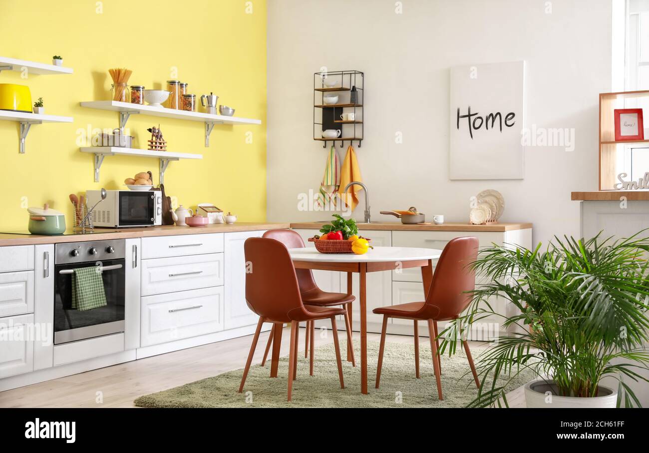 Interior of stylish modern kitchen with dining table Stock Photo - Alamy