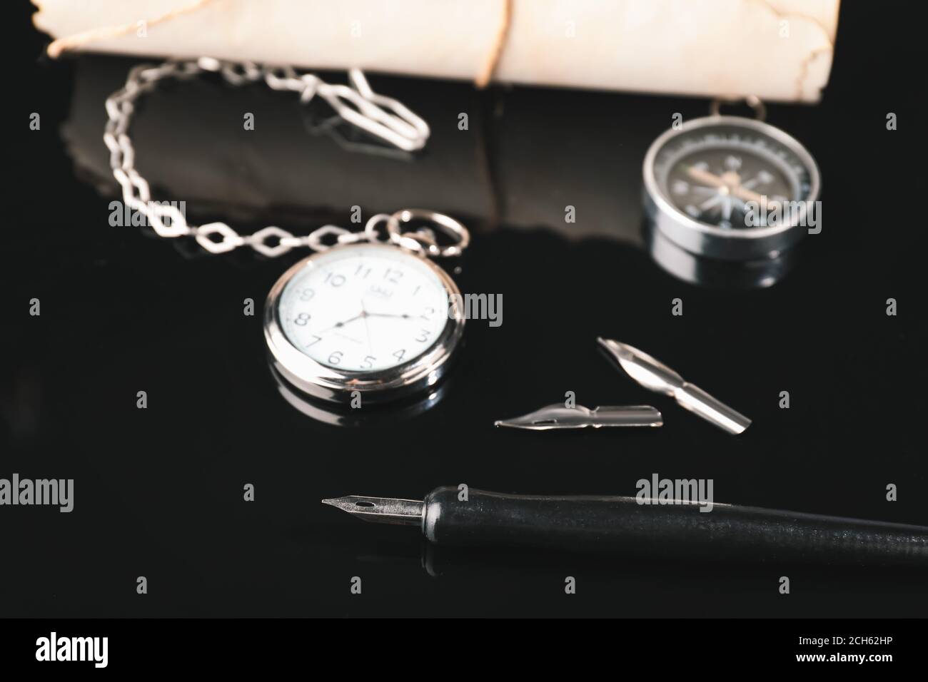 Fountain pen with pocket clock on dark background Stock Photo