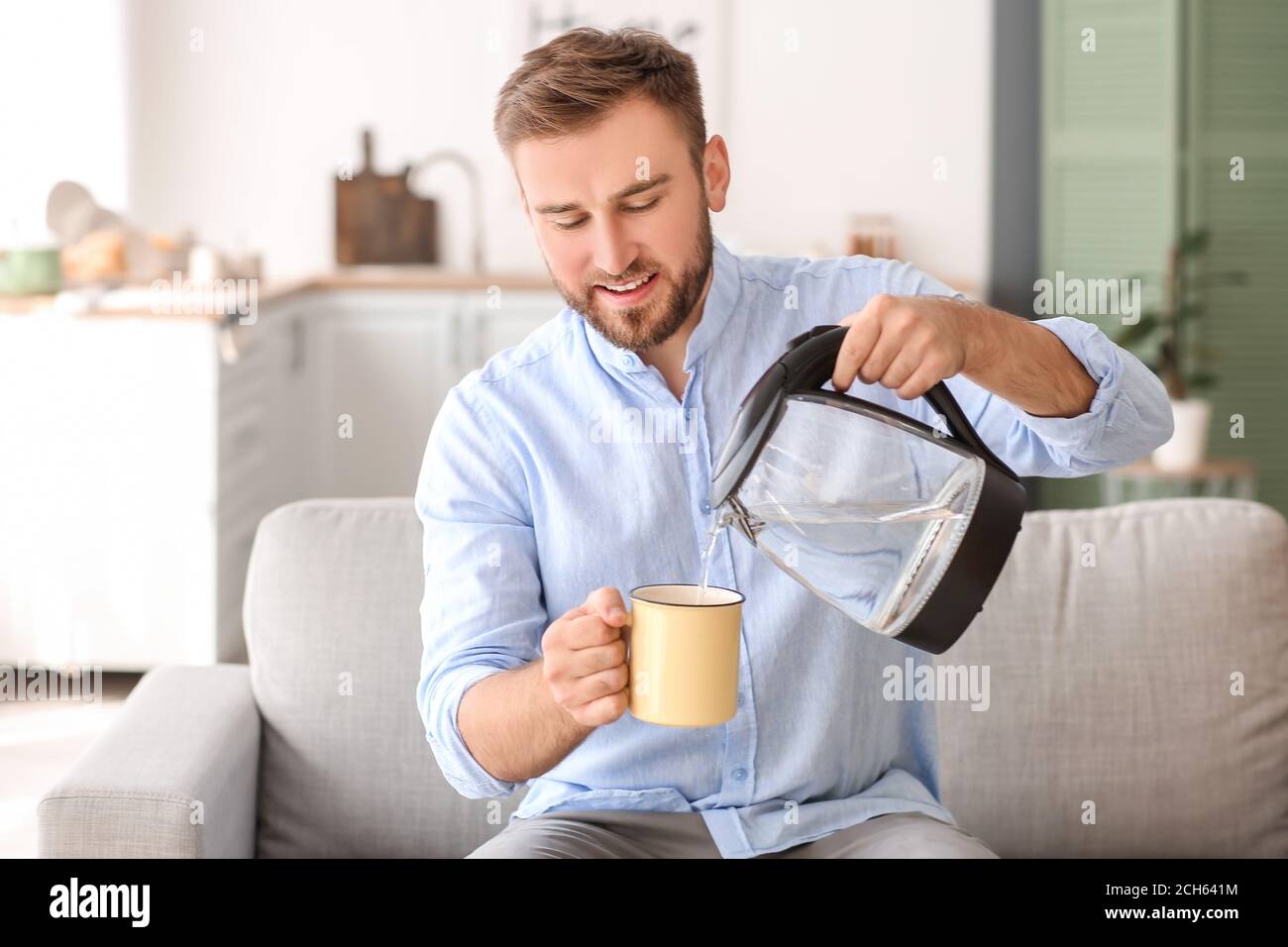 Close-up of Man Holding Thermos and an Iron Mug, Pouring Hot Tea