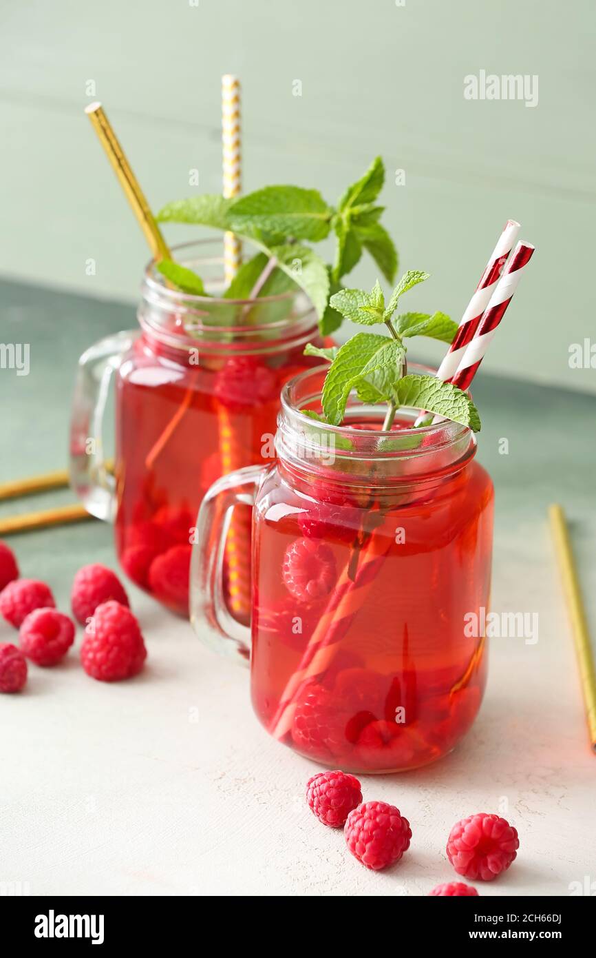 Mason jars of cold raspberry tea on table Stock Photo - Alamy