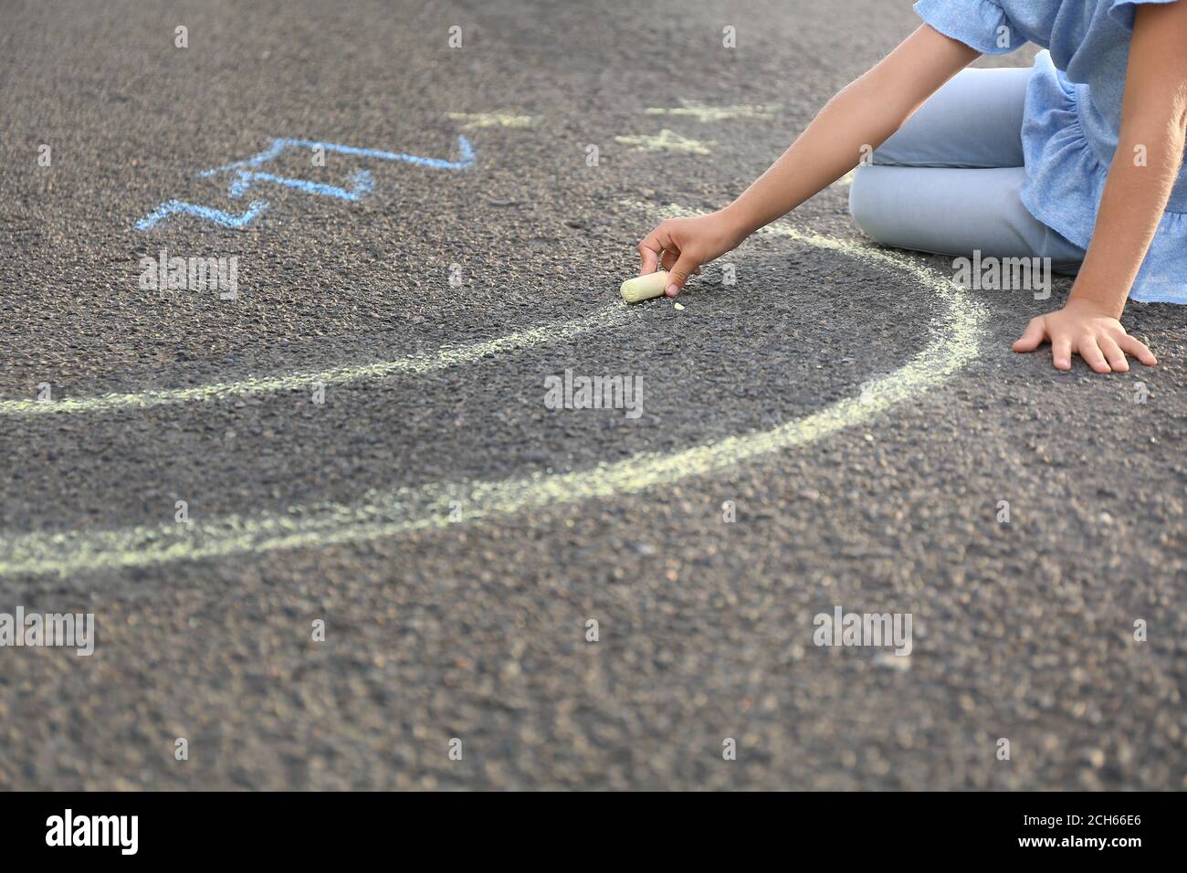 Little girl drawing with chalk on asphalt Stock Photo - Alamy