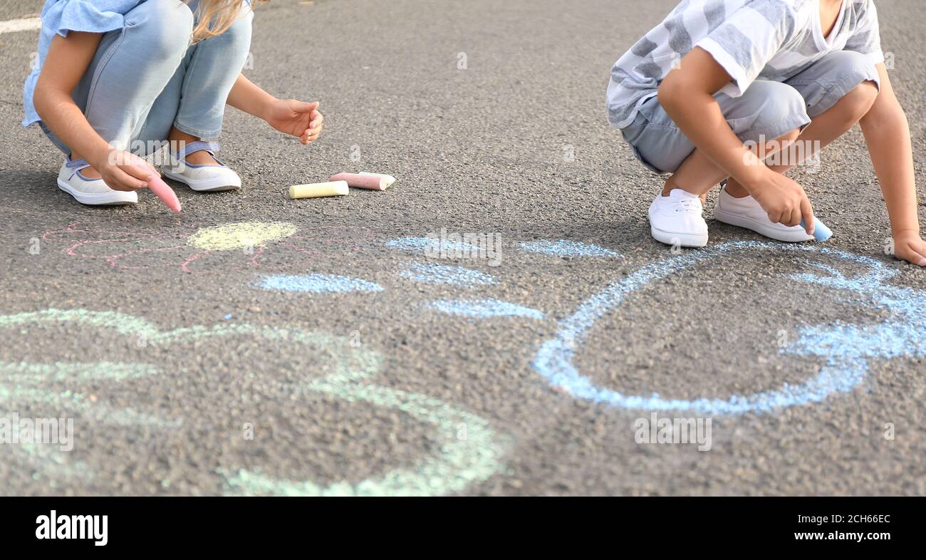 Little children drawing with chalk on asphalt Stock Photo - Alamy