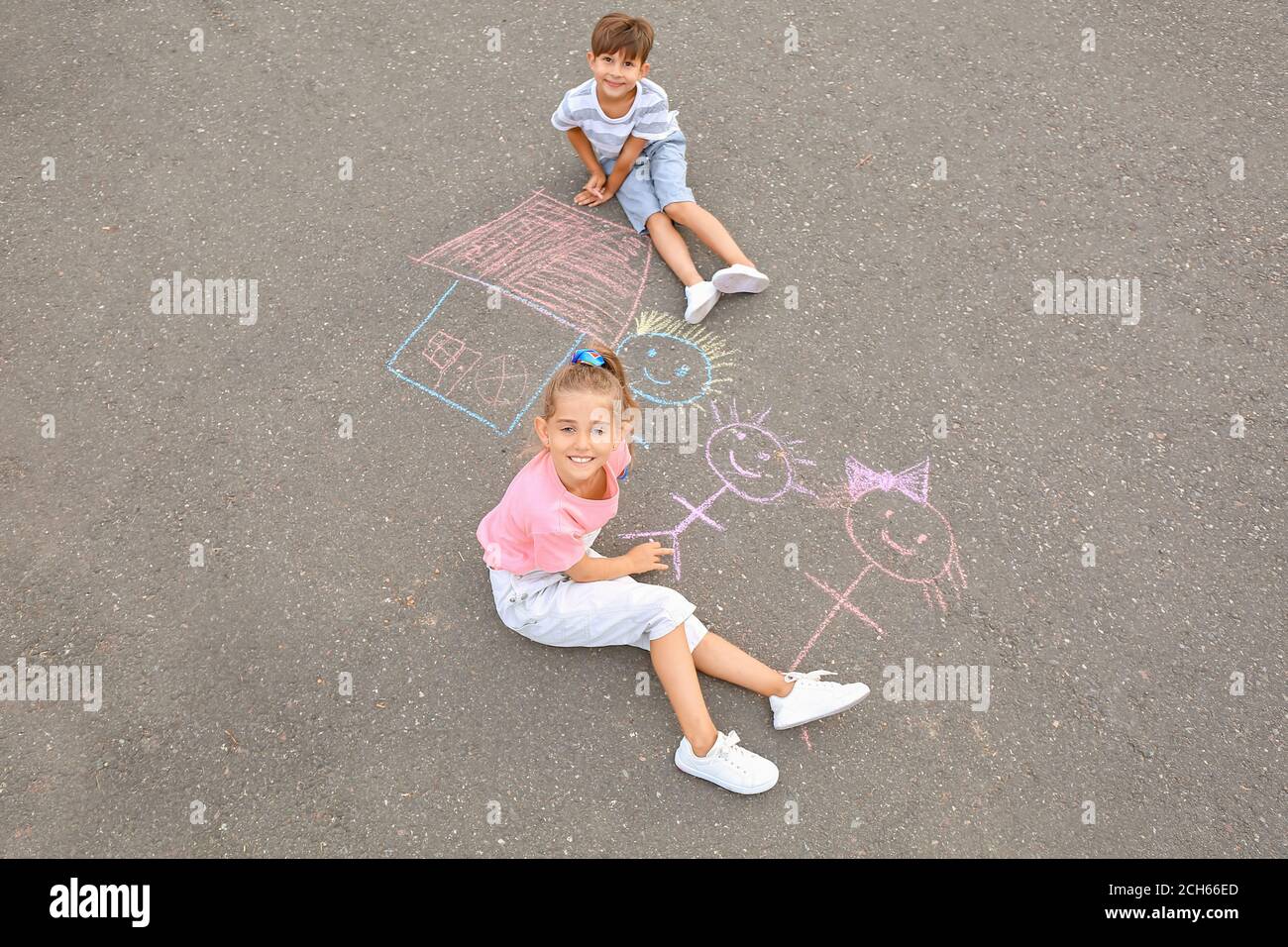 Little children drawing with chalk on asphalt Stock Photo - Alamy