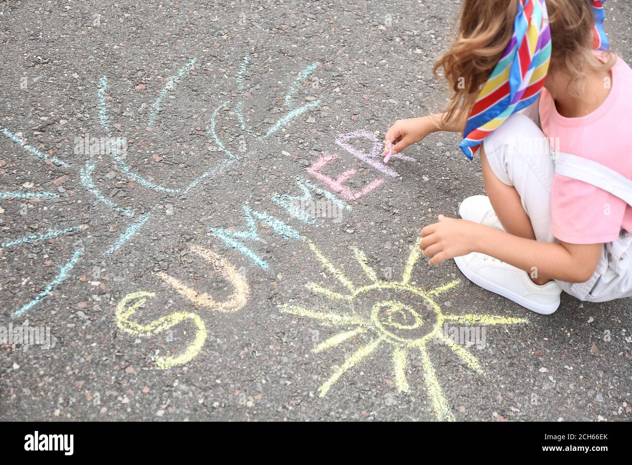 Little girl drawing with chalk on asphalt Stock Photo - Alamy