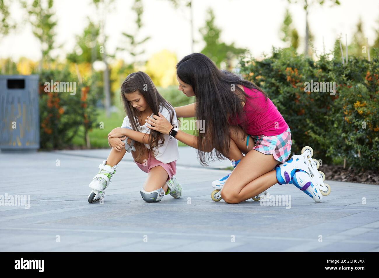 little child girl falled down while rolling with her mother in park