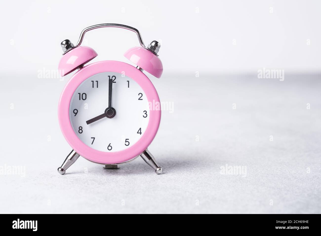 Pink alarm clock on on stone background. Copy space for text - Image Stock Photo