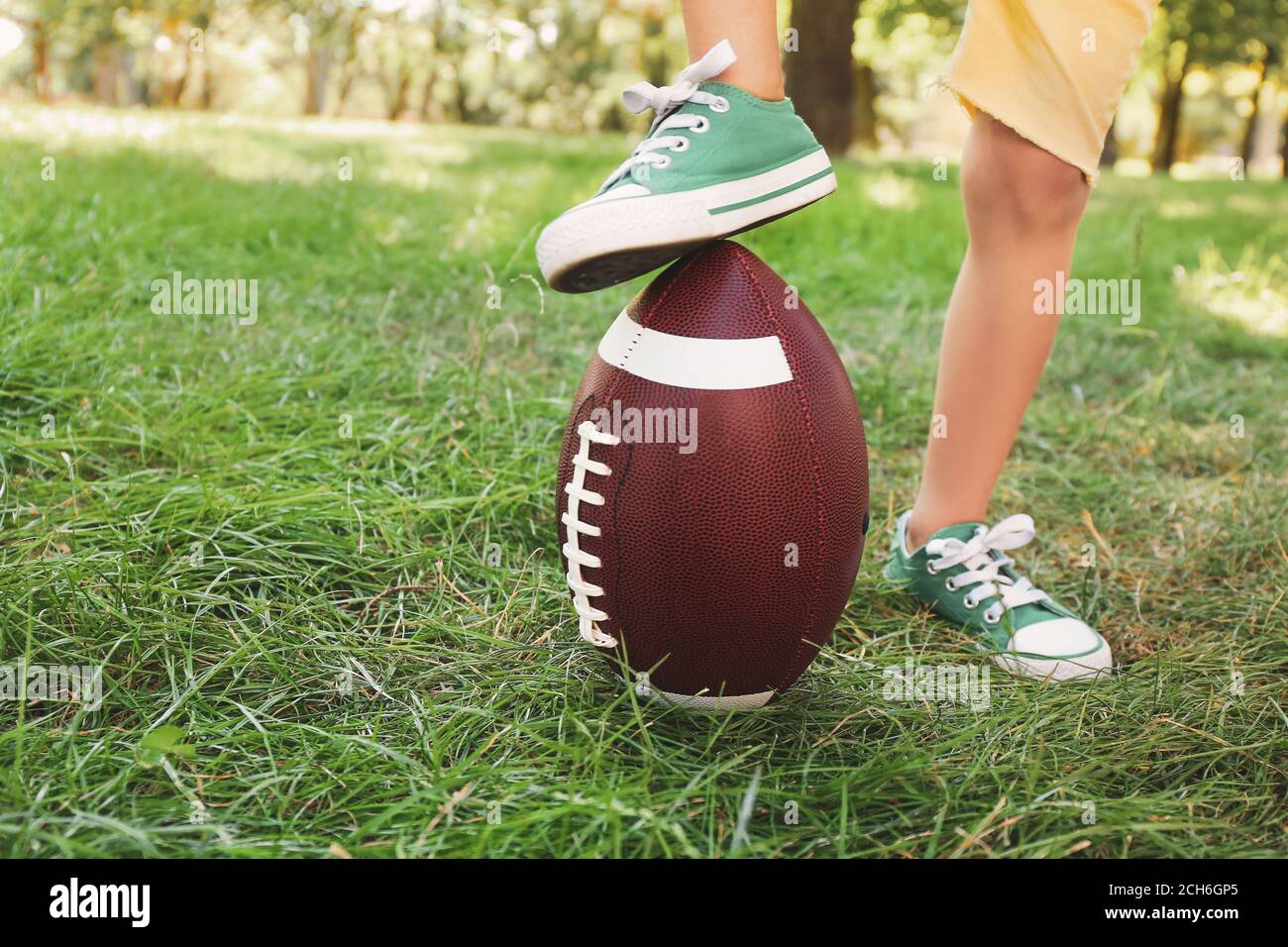 Little boy playing American football outdoors Stock Photo Alamy