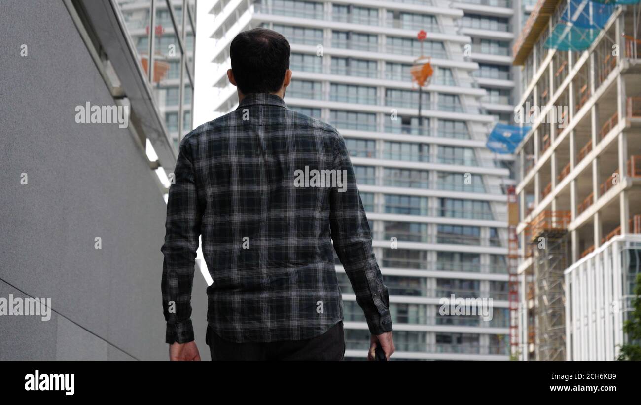 Young man walking to the modern building. Stock Photo