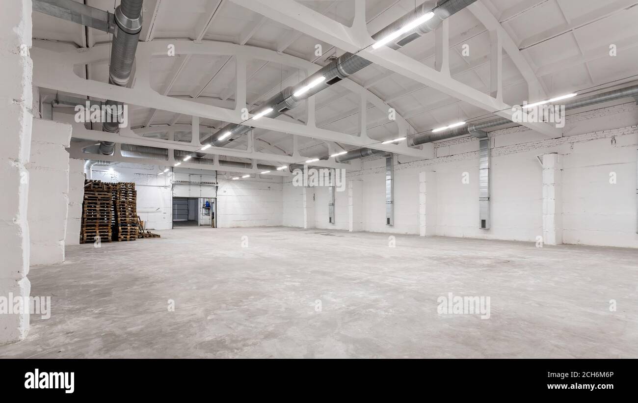 Industrial building interior with white brick walls, concrete floor and  empty space for product display or industrial background Stock Photo - Alamy