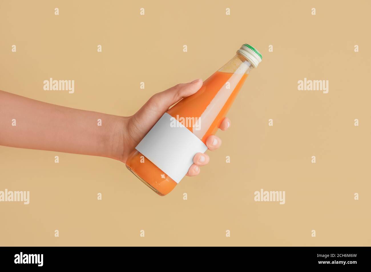 Female hand with bottle of juice on color background Stock Photo