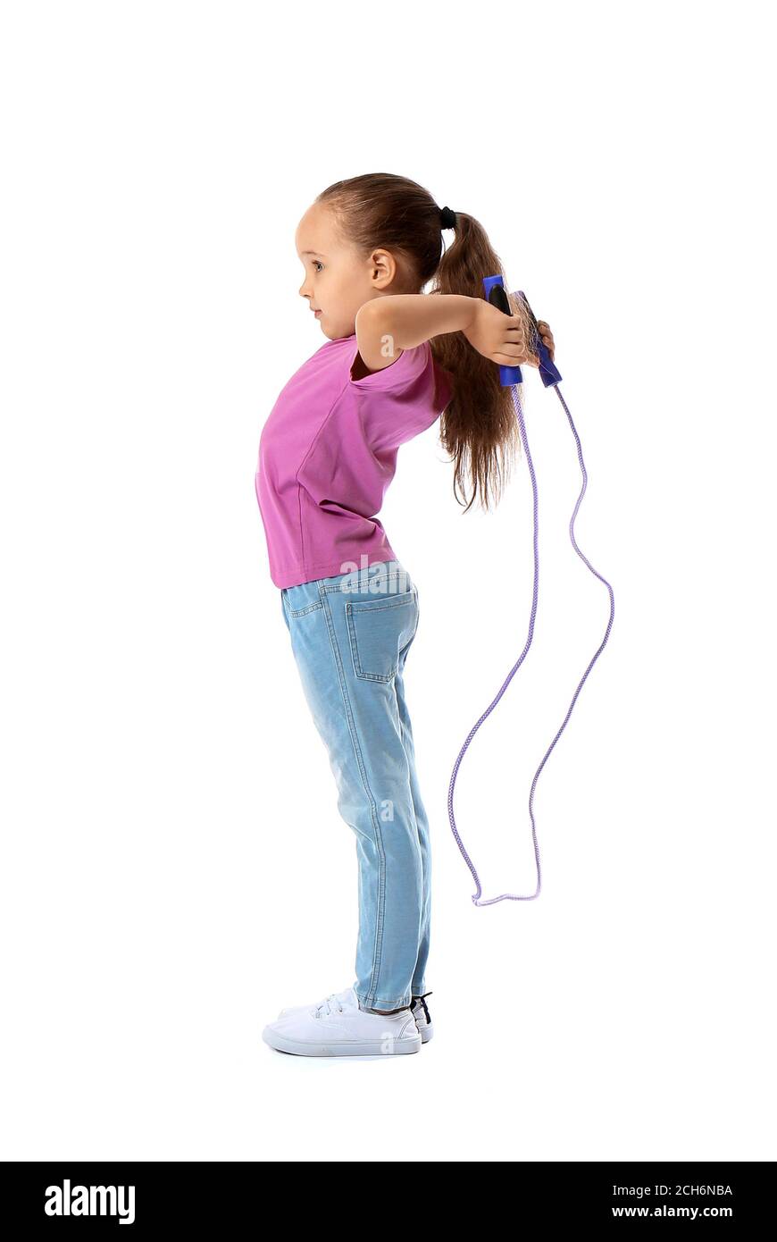 Cute little girl jumping rope against white background Stock Photo - Alamy