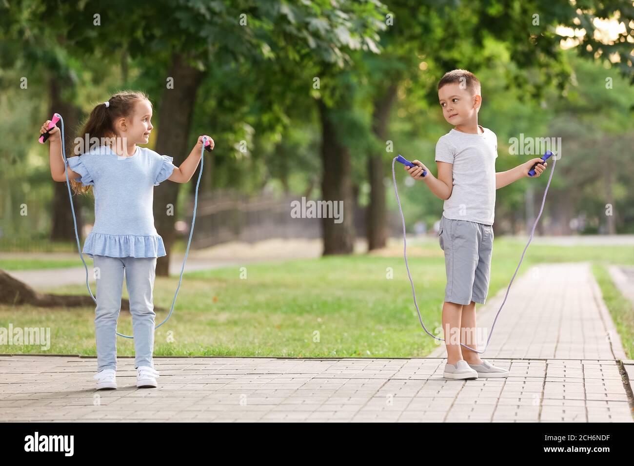 Cute little children jumping rope outdoors Stock Photo - Alamy