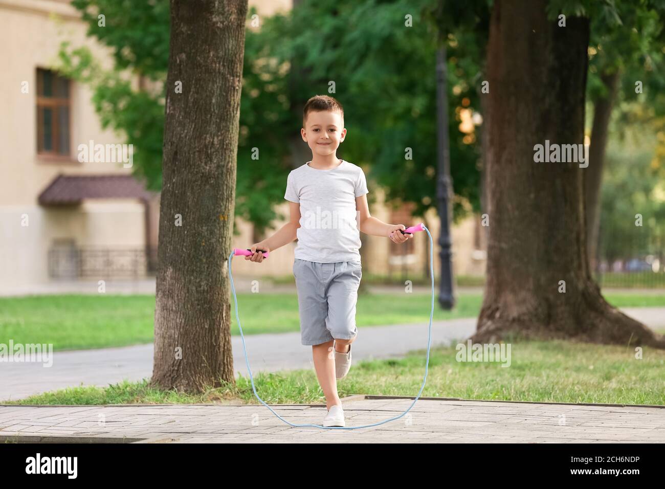 Cute little boy jumping rope outdoors Stock Photo - Alamy